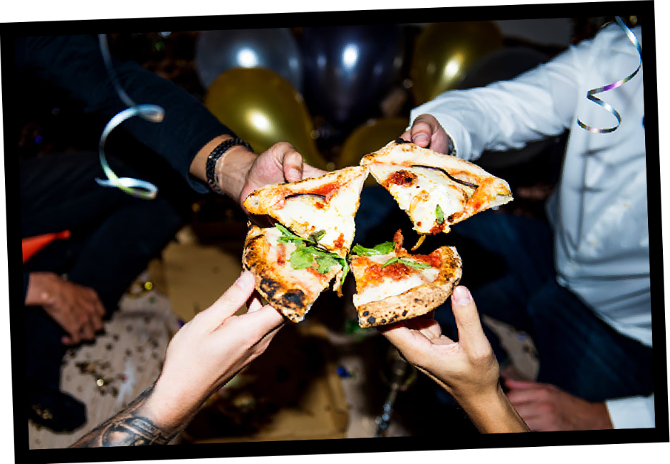 Friends raising pizza slices together