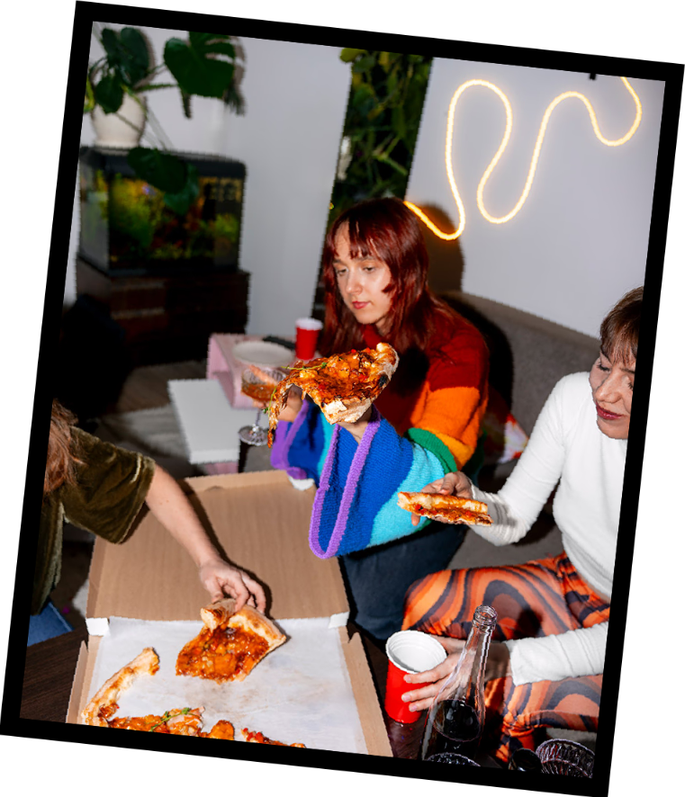 Friends enjoying pizza at a lively gathering