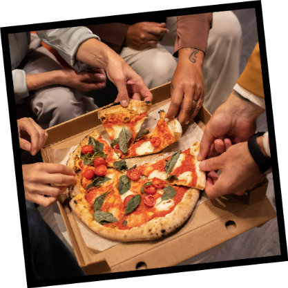 Hands reaching for slices from a shared pizza