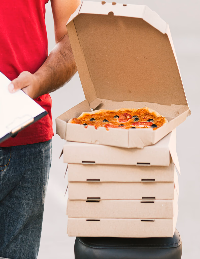 A delivery worker holding an open pizza box